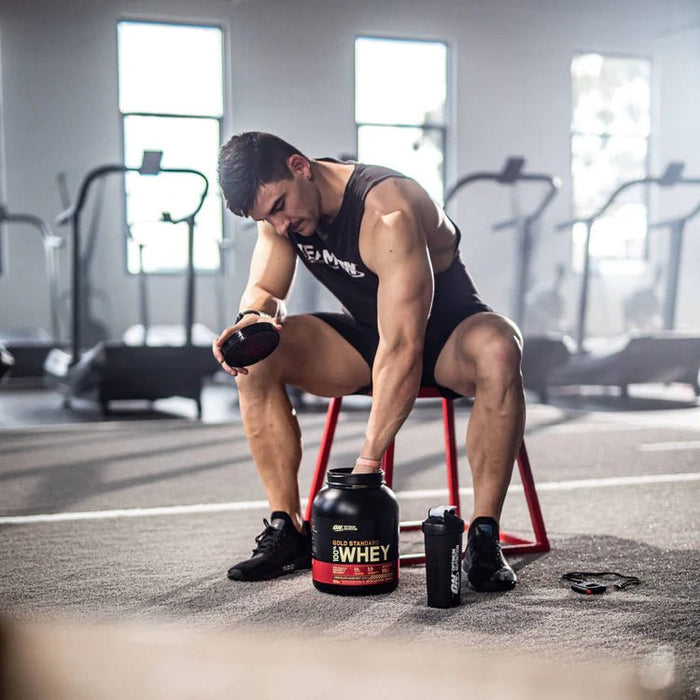 man and protein powder in gym