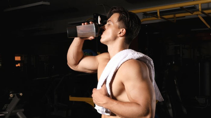 man drinking water at the gym