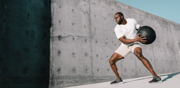 man standing holding a weighted ball